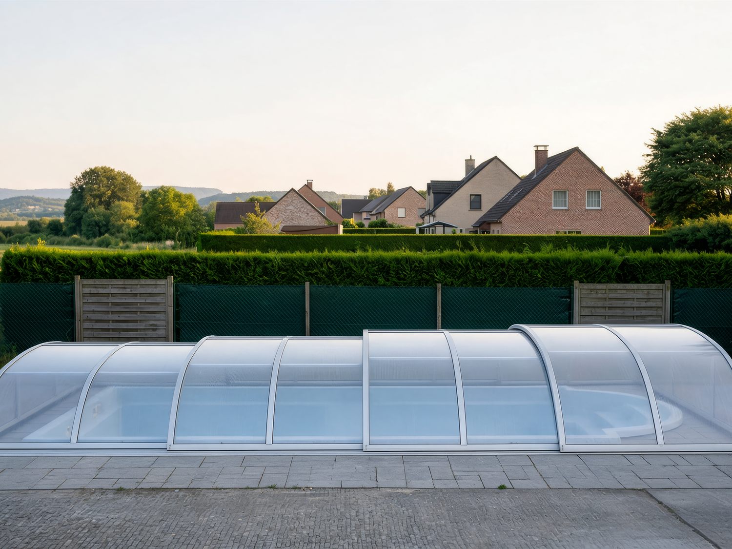 Poolüberdachung nahe der Grundstücksgrenze vor Hecke und Nachbarhäusern